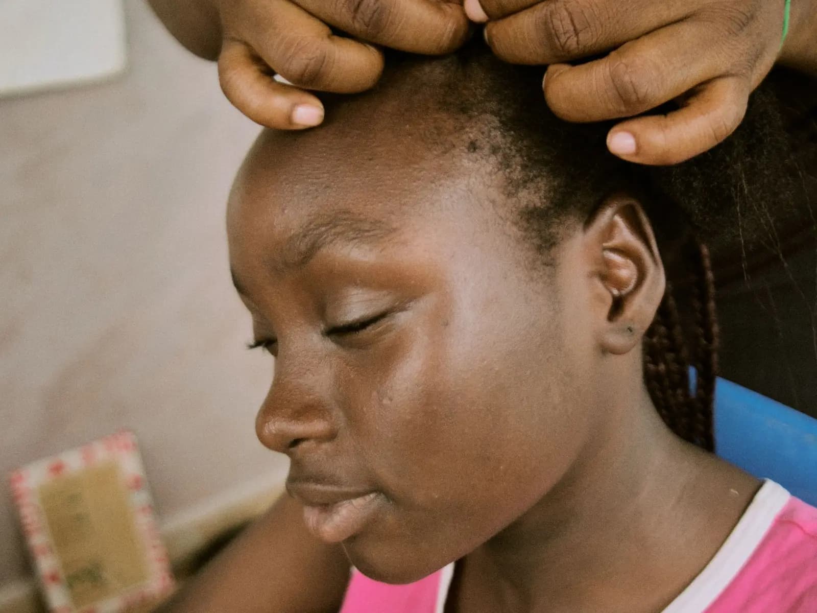 Jeune femme aux tresses, sur fond jaune.
